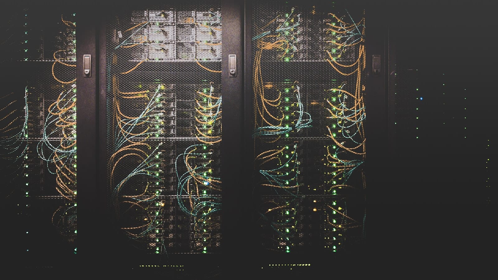 A dark data center hall with illuminated server racks and bundled cabling